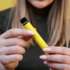 woman holding a yellow disposable vape