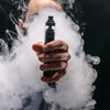 Unrecognizable man in the cloud of vape smoke. Guy smoking e-cigarette to quit tobacco