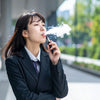 Young woman using an electronic cigarette, representing vaping and e-cigarette use